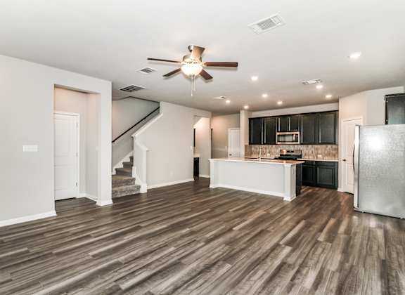 the living room and kitchen in a bedroom plus den unit.