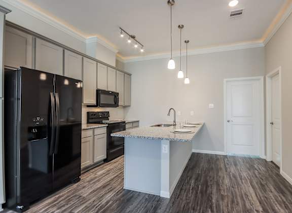 a kitchen with a large island and black appliances