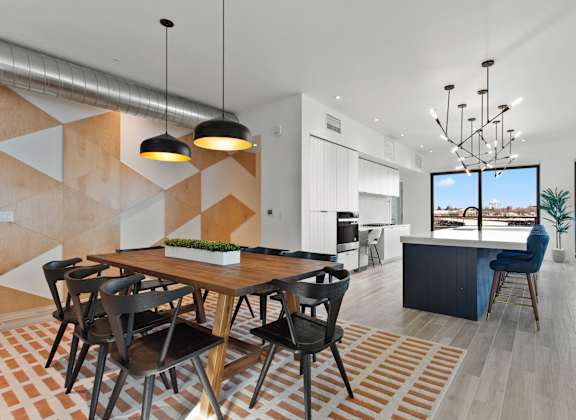 A modern dining room with a wooden table and chairs.