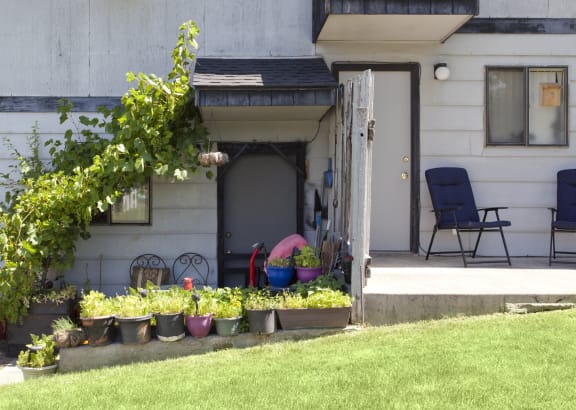 a front porch with potted plants in front of a house