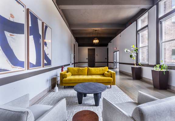 a living room with a yellow couch and a coffee table