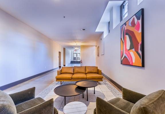 a living room with couches and chairs and a painting on the wall