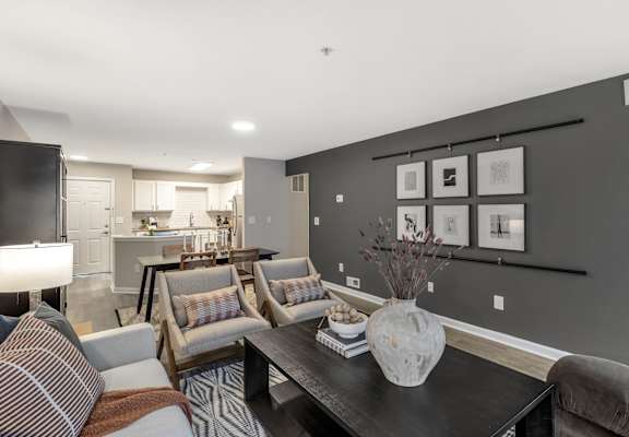 a living room with couches and a table with a vase at The Austin Apartment Homes, Deptford