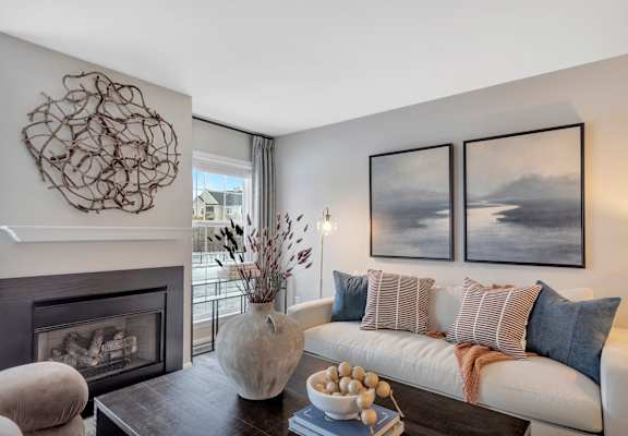a living room with a white couch and a fireplace at The Austin Apartment Homes, Deptford