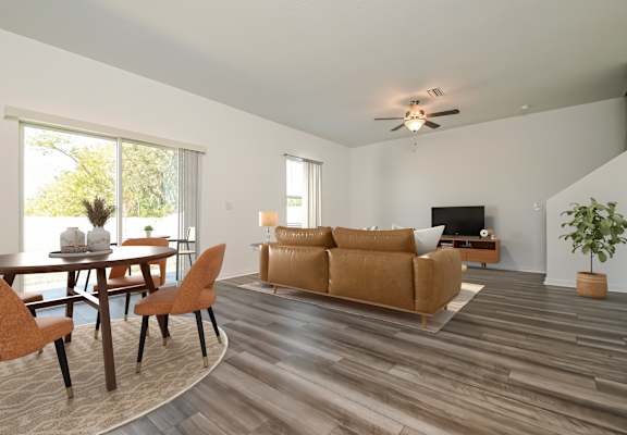 A living room with a brown couch and a wooden floor.