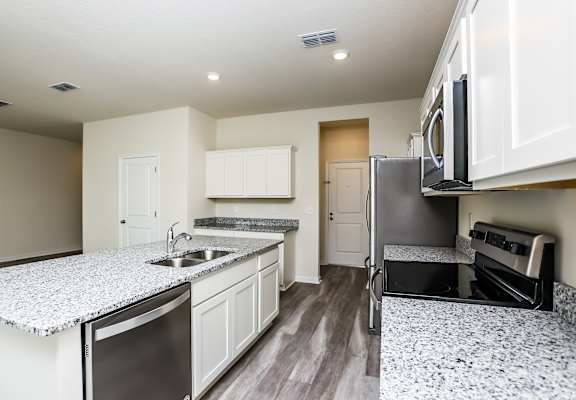 A kitchen with granite countertops and stainless steel appliances.