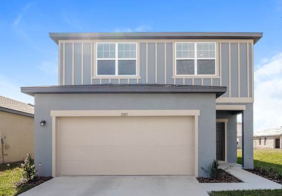 A modern house with a garage door and a driveway.
