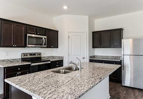 A kitchen with granite countertops and stainless steel appliances.