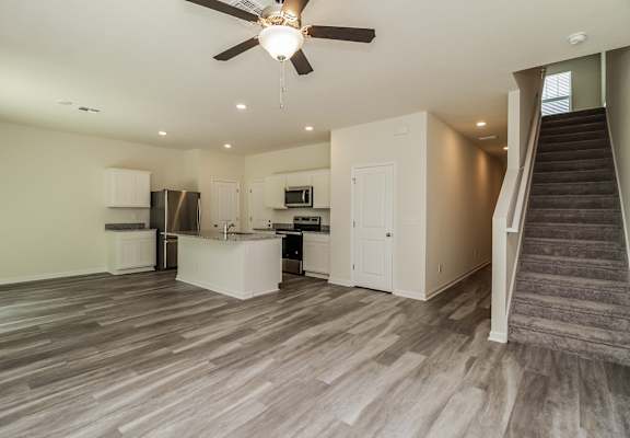 A spacious kitchen with a staircase leading to the upper floor.