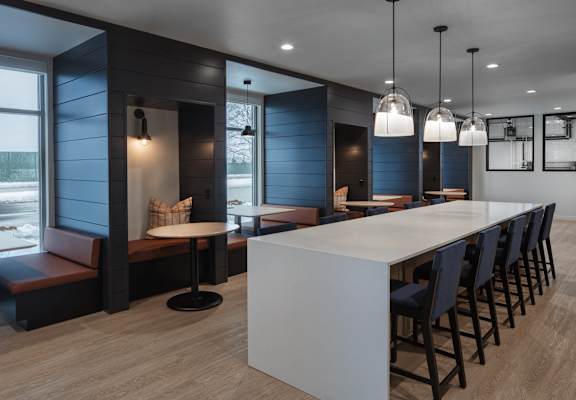 a long white counter in a restaurant with blue walls and chairs  at 2929 on Mayfair, Wauwatosa, WI