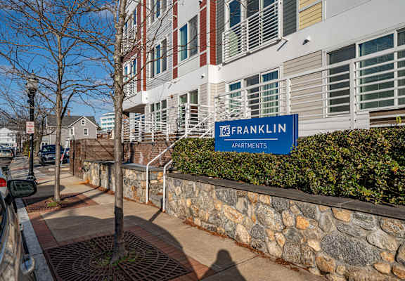 a building with a blue sign on the side of a stone wall