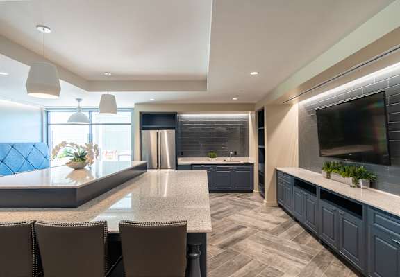 a large kitchen with a center island and a large tv
