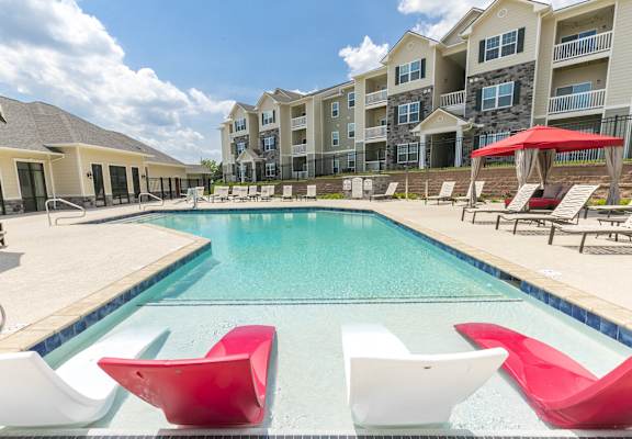 our apartments offer a swimming pool with red and white chairs at Aventura at Maryland Oaks, Missouri, 63146