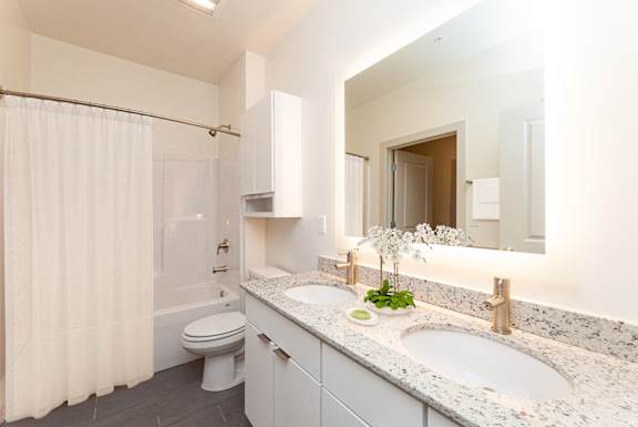 a bathroom with a white shower curtain and a white toilet next to a white sink with a
