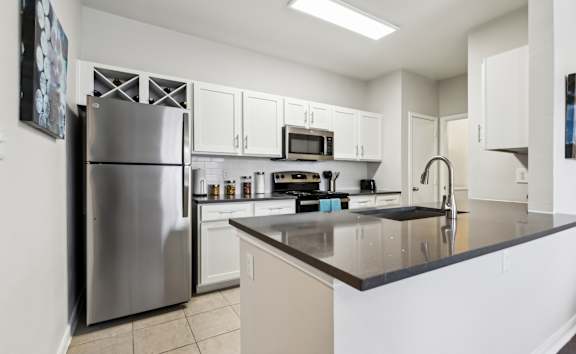 A Kitchen with a Refrigerator at Flats on Chapel Apartments, Waco