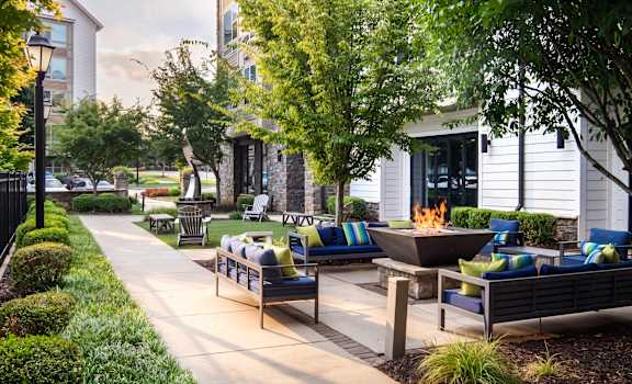 A patio with a fire pit and seating area.