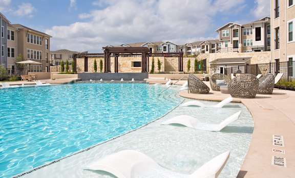 Pool surrounded by white lounge chair at Edge and Stone, Texas,