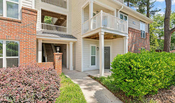 the walkway to the front of a house with a porch