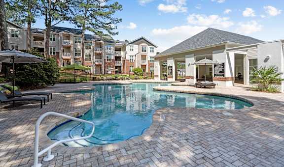 a swimming pool with an apartment building in the background