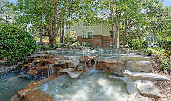 a backyard with a waterfall and rocks