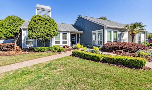 a blue house with a lawn and a sidewalk in front of it at Palmetto Place Apartments, Taylors, South Carolina