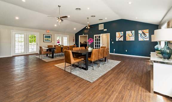 a dining room with a table and chairs and a blue accent wall