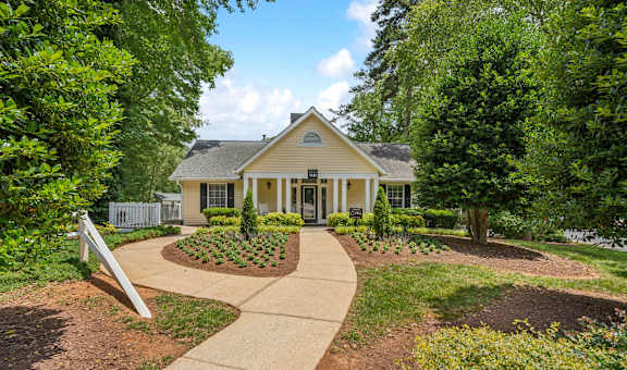 a house with a walkway leading up to it with trees