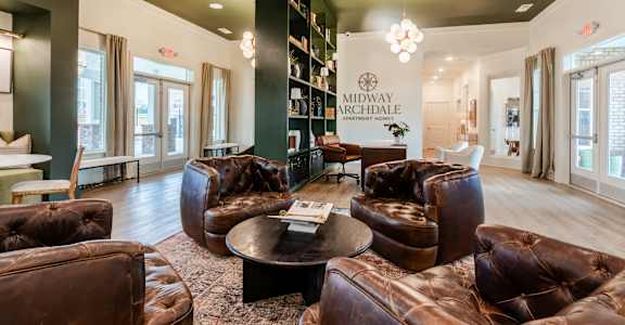 A large room with leather chairs and a coffee table.