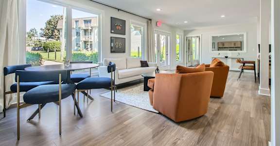 A living room with a white couch and orange chairs.