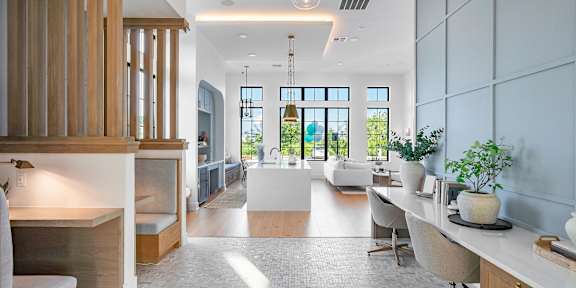 A modern kitchen with a dining area and a living room.
