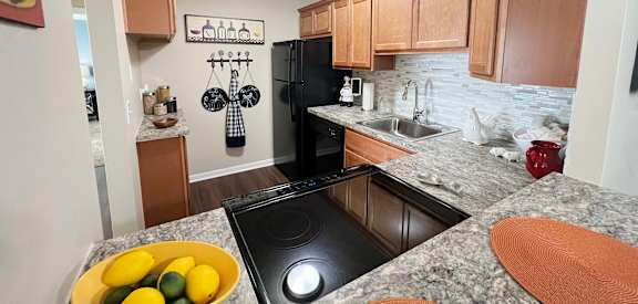full kitchen with black appliances and granite countertops at the preserve at polk apartments at Fox Run Apartments, Cincinnati