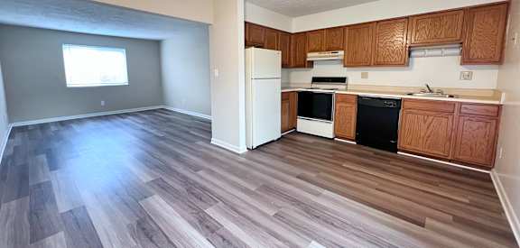 A kitchen with wooden cabinets and a white refrigerator.