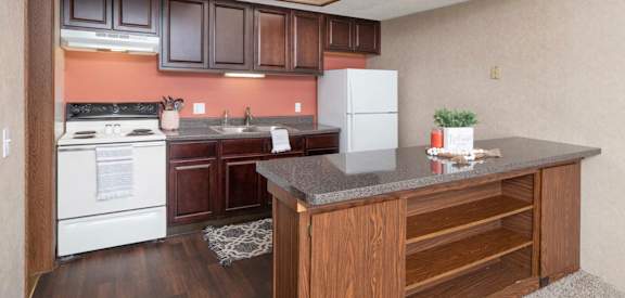 A kitchen with a white refrigerator and wooden cabinets.
