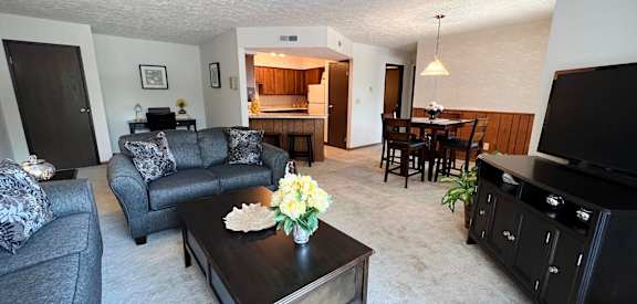 a living room with a couch and a table  at Devou Village, Ft. Wright