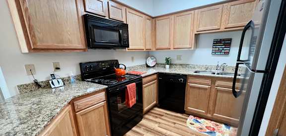 a kitchen with wooden cabinets and black appliances  at The Overlook at Ft. Thomas, Ft. Thomas, Kentucky