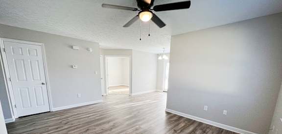 an empty living room with wood floors and a ceiling fan  at Hartland Place, Lexington, 40517