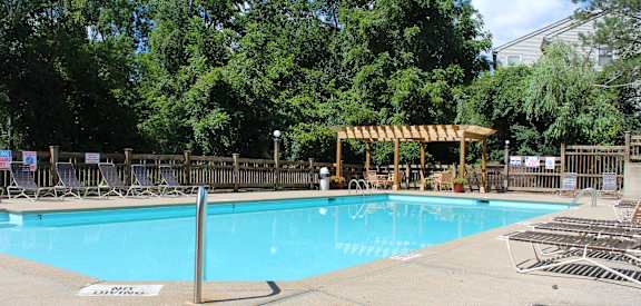 a swimming pool with chairs and a wooden fence around it  at The Vinings Apartments, Cincinnati