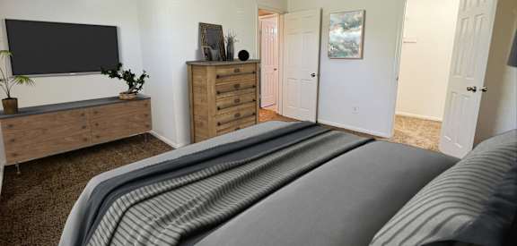 the master bedroom has a large bed and a tvat Revere Village Apartments, Centerville, OH, 45458