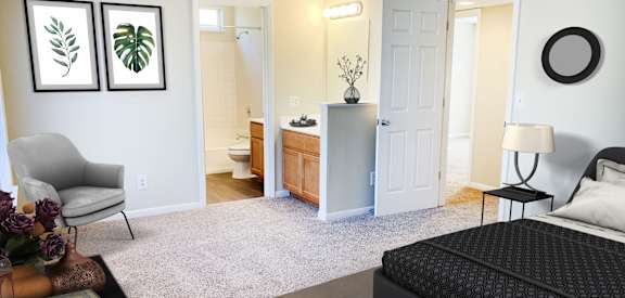 a bedroom with a large bed and a bathroom  at The Vinings Apartments, Cincinnati