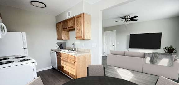 an open kitchen and living room with a dining table and a white stove and refrigerator