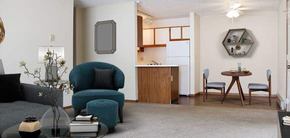 a living room with a couch and a chair and a kitchen with a table  at Wyndemere Apartments, Franklin, OH