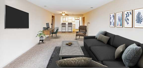 A living room with a grey sofa and a black TV on the wall.