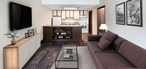 A living room with a brown couch and a television on the wall.