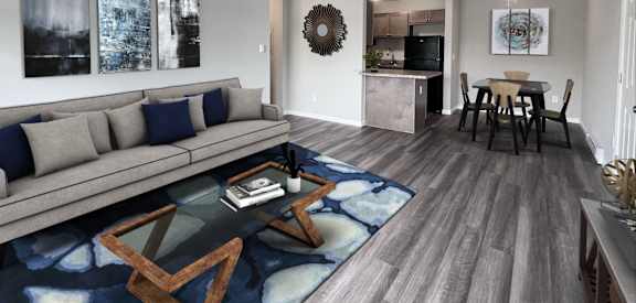 A modern living room with a grey sofa and a glass coffee table.