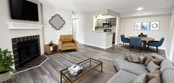 A living room with a grey couch and a fireplace. at Deercross Apartments, Cincinnati, Ohio