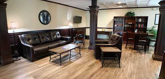 a living room with leather couches and chairs and a table  at Knobs Pointe Apartments, New Albany, Indiana