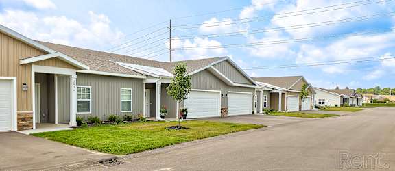 A row of houses with a tree in front of them.
