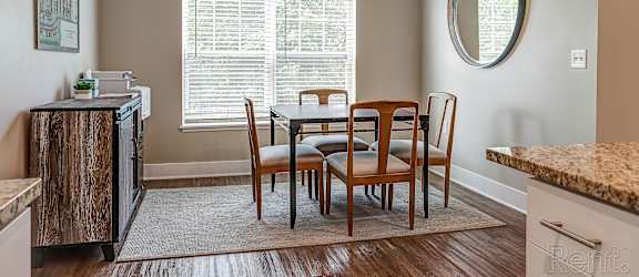 A kitchen with a dining table and chairs.