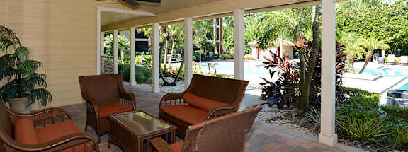 A patio with a ceiling fan and chairs.