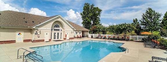 A large outdoor swimming pool with a building in the background.